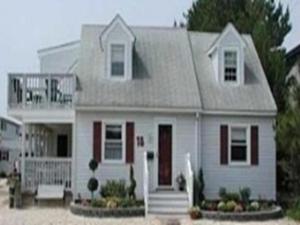 a white house with a porch and a balcony at Ocean Side Home In Brant Beach 36525 in Brant Beach