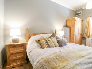 a bedroom with a bed and a nightstand with two lamps at The Old Dairy in Herne Bay