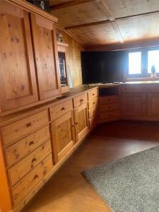 普夫龙滕Ferienwohnung Zugspitzblick - Haus Alpentenne, Pfronten的带木质橱柜和窗户的大厨房