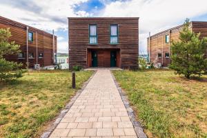 a wooden house with a walkway in front of it at LAGOVIDA Hafenhaus j am Störmthaler See in Großpösna