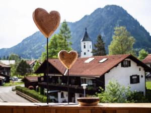 普夫龙滕Ferienwohnung Kuschelnest - Haus Alpentenne, Pfronten的教堂前桌子上的两颗心