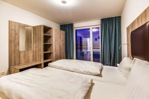 a bedroom with two beds and a window at LAGOVIDA Leuchtturm am Störmthaler See in Großpösna