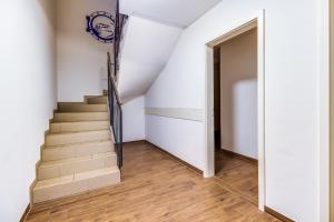 a hallway with stairs and an open door at LAGOVIDA Leuchtturm am Störmthaler See in Großpösna