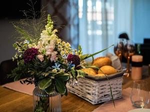 普夫龙滕Ferienwohnung Alpenblick - Haus Alpentenne, Pfronten的花瓶里满是鲜花和一篮水果 更多12张照片