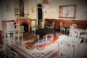 una camera con sedie bianche, tavolo e camino di Hotel El Xalet a Sitges