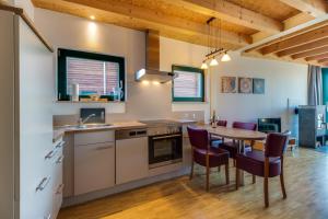 a kitchen and dining room with a table and chairs at LAGOVIDA Hafenhaus d am Störmthaler See in Großpösna
