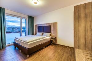 a bedroom with a bed and a large window at LAGOVIDA Ankerplatz b am Störmthaler See in Großpösna +28 photos