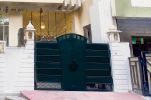 a green gate in front of a building at Super Hotel O Sikar Road Jaipur Formerly Garg Niwas in Jaipur +27 photos