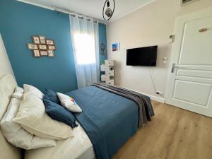 a bedroom with a bed and a flat screen tv at A 3 PAS DE LA PLAGE DE SANT'AMBROGGIO in Lumio