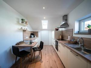 普夫龙滕Ferienwohnung Breitenbergblick - Haus Alpentenne, Pfronten的带水槽和桌椅的厨房
