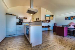 a kitchen with white cabinets and a counter top at LAGOVIDA Dünenhaus Comfort i am Störmthaler See in Großpösna