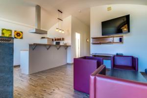 a dining room with a table and purple chairs at LAGOVIDA Dünenhaus Comfort i am Störmthaler See in Großpösna