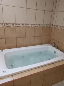 a white bath tub in a tiled bathroom at Kenai Mountain View in Concepción +33 photos