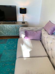 a living room with a white couch with purple pillows at Multiverse in Podstrana