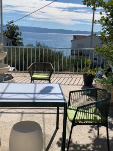 two chairs and a table on a patio with the ocean at Multiverse in Podstrana