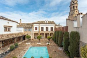 an exterior view of a mansion with a swimming pool at Hotel Puerta de la Luna in Baeza
