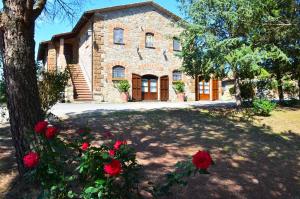 a stone house with red roses in front of it at Agriturismo Sant'Angelo in Acquapendente