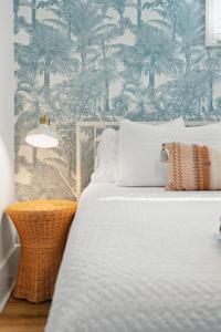 a bedroom with a bed with a palm tree wallpaper at Folliday Inn - The Runabout - Room 12 in Folly Beach