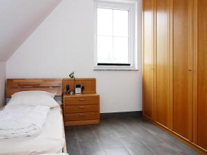 a bedroom with a bed and a window at Ferienhaus Lotsenhaus am Breetzer Bodden in Vieregge