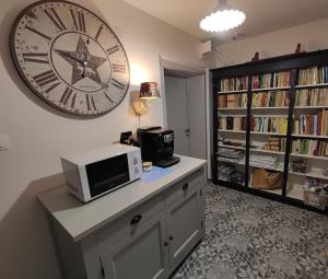 a room with a large clock on the wall and a microwave at Apartmán Šumiac 2 in Šumiac
