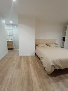 una camera da letto con un letto e un pavimento in legno di Bas de Villa avec entrée indépendante en pleine nature a Le Bar-sur-Loup