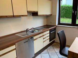 una cocina con fregadero y lavavajillas en Ferienwohnung Rhönauszeit, en Stockheim