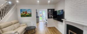 a living room with a couch and a fireplace at 4 Bed 3 Bath Dryer Sky TV & Netflix Free Parking Rear Garden Prime Location in Willen