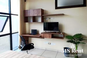 ein Zimmer mit einem Fernseher an einer Wand mit einem Stuhl in der Unterkunft Centrico Espacio Cruceño Full in Santa Cruz de la Sierra