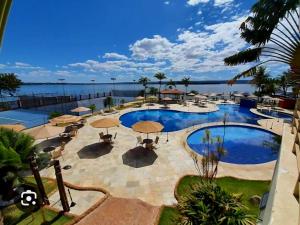 a large swimming pool with umbrellas and the ocean at Premier Residence in Brasilia