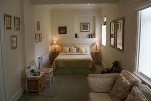 um quarto com uma cama e um sofá em The Norwood Guest House em Southport