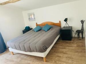 a bedroom with a bed with blue pillows and a giraffe at Gite centre village Burlats in Burlats