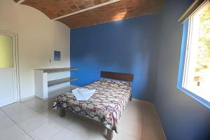 a bedroom with a bed in a blue wall at C11 · Casa 2 niveles, alberca y vista al manglar in La Peñita de Jaltemba +54 photos