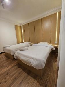 three beds in a room with wooden floors at Sheraton Ocean 103 - Without Pool access in Cairo +22 photos