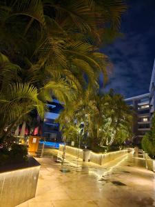 a park with palm trees and buildings at night at Sheraton Ocean 103 - Without Pool access in Cairo