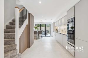 a kitchen with a staircase and a dining room at Queens Mews Brand New Luxury Home with Parking in Henley on Thames