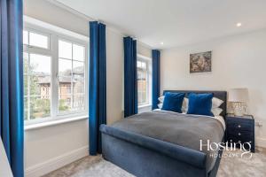 a bedroom with a bed and two windows at Queens Mews Brand New Luxury Home with Parking in Henley on Thames