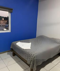 a bed in a room with a blue wall at C12 · Casa 2 niveles, alberca y vista al manglar in La Peñita de Jaltemba +62 photos