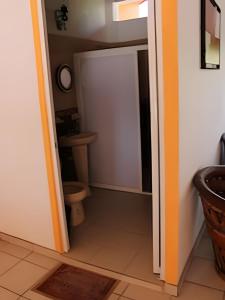 La salle de bains est pourvue de toilettes et d'une porte blanche. dans l'établissement C2 Alberca privada a 5 min de la playa, en planta alta, à La Peñita de Jaltemba