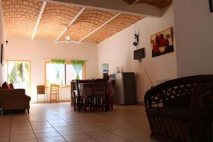 un salon avec une table et un réfrigérateur dans l'établissement C2 Alberca privada a 5 min de la playa, en planta alta, à La Peñita de Jaltemba