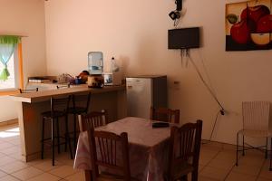 une cuisine avec une table et un réfrigérateur dans l'établissement C2 Alberca privada a 5 min de la playa, en planta alta, à La Peñita de Jaltemba