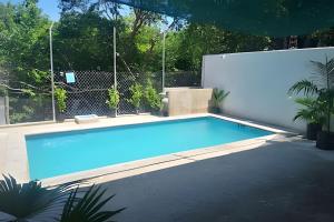 a swimming pool in a backyard with a fence at C3 Alberca privada a 5 min de la playa y manglar! in La Peñita de Jaltemba