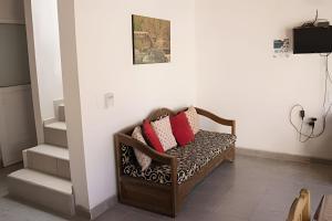 a chair with pillows on it in a room at C9 Casas la colmena a 3 min playa alberca 2 rec. in La Peñita de Jaltemba