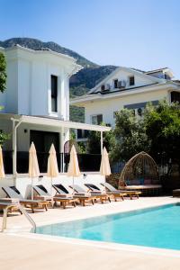 a group of chairs with umbrellas next to a swimming pool at Marla Suite Fethiye in Fethiye