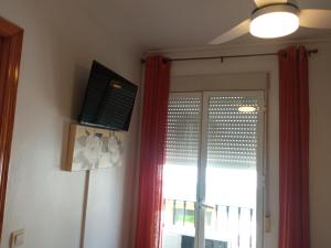 a room with a window and a red curtain at La Casita 18 in Ardales