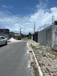 an empty street with a car parked on the side of the road at Casa com Piscina em Enseada in Cabo de Santo Agostinho