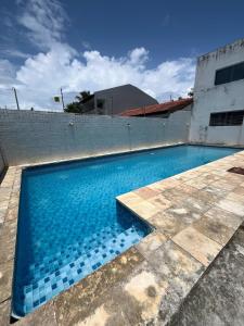 a swimming pool with blue water in front of a building at Casa com Piscina em Enseada in Cabo de Santo Agostinho