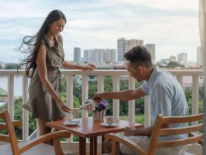金边金边索菲特佛基拉酒店 的坐在阳台上桌子上的男人和女人 更多37张照片