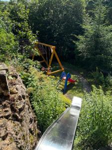 a childrens playground with a bench and a swing at Fischer Hütte in Sankt Andreasberg