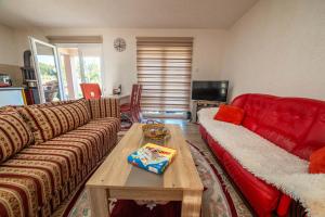 a living room with a red couch and a coffee table at Hacienda Antioquia in Berane