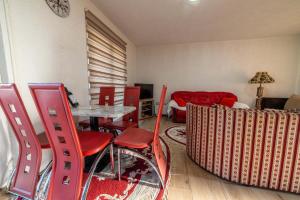 a living room with red chairs and a table at Hacienda Antioquia in Berane
